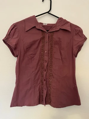 Mörkrosa unik blus  - Väldigt unik mörkrosa blus men fina broderier på både framsida och baksida. Har en liten liten blekning på framsidan (bild 3) och små små hål på baksidan (bild 4) men inget som märks i helheten av tröjan.
