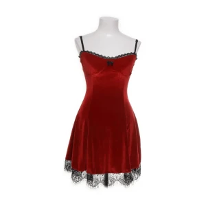 Rött sammetnattlinne med spetsdetaljer - Snyggt rött nattlinne i mjuk sammet med svarta justerbara axelband och spetskant vid urringning och nederkant. Liten rosett framtill för extra detalj. Perfekt för mysiga kvällar hemma.