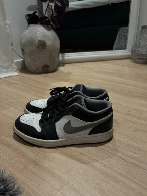 Nike Air Jordan 1 Low svart/vit - Säljer ett par Nike Air Jordan 1 Low sneakers i svart och vitt. Nästan helt nya. Har köpt dem själv för 1400kr