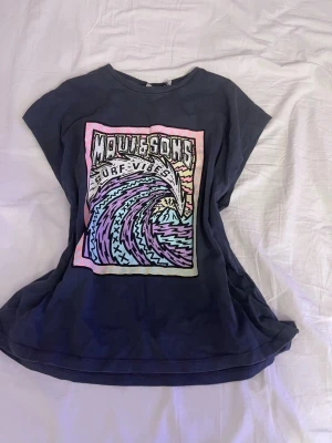 Mörkblå t-shirt Maui & Sons x Zara - Cool mörkblå t-shirt från Zara med Maui & Sons-tryck framtill i pastellfärger. Motiv med vågor och texten 'Surf Vibes' ger en avslappnad känsla. T-shirten är kortärmad och gjord i mjuk bomull, perfekt för en chill och trendig look.