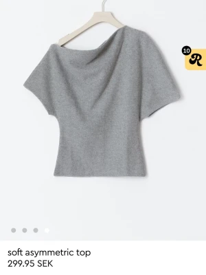 Grå asymmetrisk topp - Trendig grå topp med asymmetrisk halsringning och korta ärmar. Änvädn endast 1 gång så iprincip helt ny! Storlek S! 