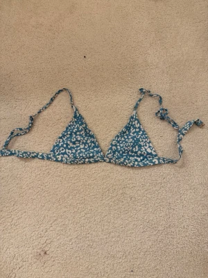 Blå leopardmönstrad bikiniöverdel - Säljer en blå trekantsbikini med vitt leopardmönster. Perfekt för strandhäng och sommarens alla bad. Materialet är mjukt och följsamt syntet. Shein
