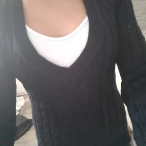 Svart stickad v-ringad tröja - Svart stickad tröja med snygg v-ringning och kabelstickat mönster. Långärmad och figurnära passform som sitter riktigt bra. Perfekt att matcha med jeans eller kjol för en chill look. Från shein