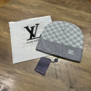 Rutig mössa gråvit  - En rutig gråvit mössa sitter tajt och bra på huvudet. Perfekt till höst och vintern 