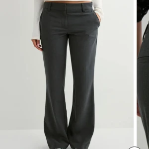 Low waist flare suit pant  - Gråa Lågmidjade kostymbyxor ifrån Nelly. Storlek 42 knappt använda. 