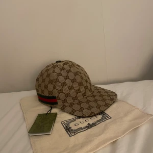 Gucci keps med GG-mönster och röd/grön detalj - Jätte fet keps, skick 9/10 nästan helt ny använd några gånger men jättefint skick, säljer för att de inte är min stil längre.