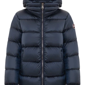 Mörkblå Colmar pufferjacka med huva - Säljer en mörkblå pufferjacka från Colmar med stor, mysig huva och markerad logga på ärmen. Skriv för mer bilder!! Jackan är i väldigt bra skick! Köpt förra vintern