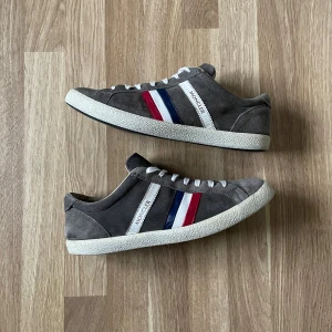 Moncler skor i grå mocka - Ett par grå moncler skor i mocka. Skorna är i storleken 44. Bra skick men en reva på insidan( skriv för bild ). Original kartong finns inte. 