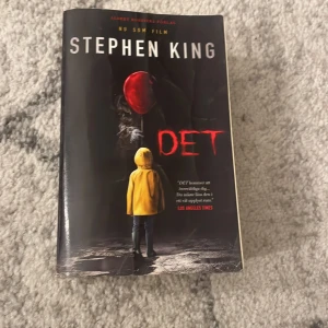 DET - En skrämmande och spännande bok av Stephen King. Omslaget visar en person i gul regnjacka och en röd ballong, vilket ger en mystisk och kuslig känsla. Perfekt för dig som gillar rysare och vill ha en bok som håller dig på helspänn.