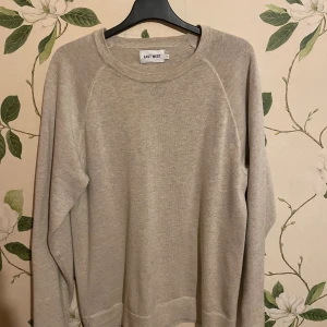 Beige sweatshirt från East West - En stilren beige sweatshirt från East West i storlek S. Tröjan har rund halsringning och långa ärmar, perfekt för chill dagar. Materialet känns mjukt och skönt mot huden, och den neutrala färgen gör den enkel att matcha med allt i garderoben.