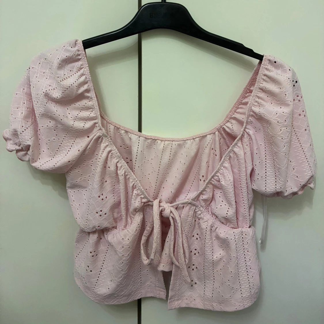 Ljusrosa blus med knyt och volang