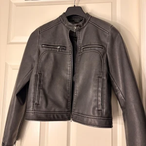 Grå skinnjacka med dragkedjor - Grå skinnjacka från Noisy May. Helt ny utan prislapp, endast provad. Nypris 799kr. Önskas fler bilder så fixar jag det! 