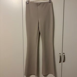 Beige bootcut byxor från H&M - Beige bootcut-byxor från H&M i storlek M. Endast testad! Liknar kostymbyxor och är väldighet sköna. Innerbenslängden är 78 cm, och den har stretch i midjan💖