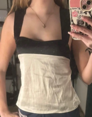 Svartvit linnetopp med breda band Shein - Säljer en svartvit linnetopp från Shein i storlek XS. Toppen har breda svarta axelband, fyrkantig urringning och knytband i ryggen. Materialet är lätt och känns som polyester, perfekt för varma dagar. Enkel men ändå stylish design som sticker ut.