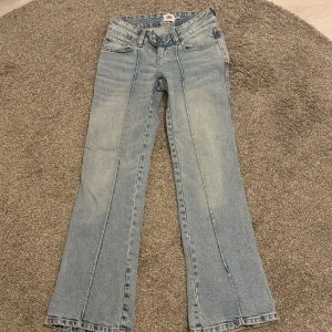 Bootcut jeans från Lager 157 (Paris XS) - Ljusblå bootcut jeans från Lager 157 (Paris i storlek XS Short). Klassisk femficksmodell med dubbla knappar i midjan och snygga söm-detaljer längs benen. Jeansen har en lätt tvättad look och är tillverkade i mjukt denimtyg.