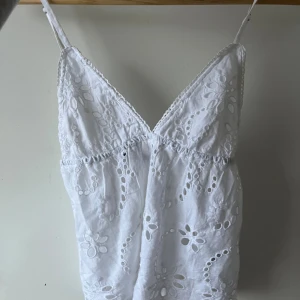 Vit broderad linnetopp med spets - Säljer en vit linnetopp med tunna justerbara axelband och v-ringad hals. Storlek 36, från Gina Tricot ❤️