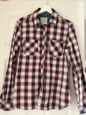 Peak Performance rutig skjorta - Rutig skjorta, stl XL, väldigt fint skick.  Modell Iris. Röd/blå. Fina jeansdetaljer och pärlemorknappar. 