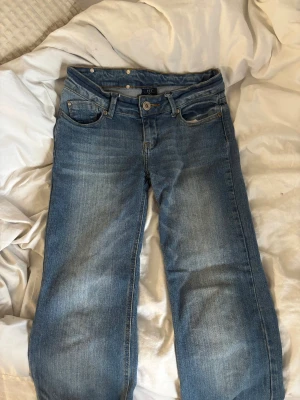 Blå jeans från YFK Jeans, storlek M - Snygga blå jeans från YFK Jeans i klassisk femficksmodell. Jeansen har raka ben, normal passform och coola detaljer på bakfickan. Tillverkade i slitstarkt denim med ljus tvätt och kontrastsömmar. Perfekta för dig som gillar en enkel och tidlös stil. Pris går att diskutera❣️