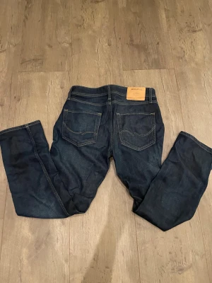 Mörkblå jeans från Jack & Jones - Snygga mörkblå jeans från Jack and Jones. Storlek 29/30 i Regular fit. Jeansen är sköna och knappt använda. Mitt pris är 100 kr.