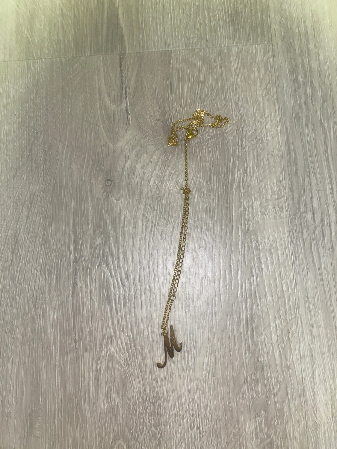 Guldigt halsband med bokstaven M