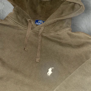 Brun Ralph Lauren hoddie  - Snygg Polo Ralph Lauren hoodie i en varm brun färg. Mjuk, bekväm och perfekt för dig som vill ha en clean och stilren hoodie med premiumkänsla.  Skick: ✔ Bra begagnat skick ✔ Mjuk fleece på insidan ✔ Inga hål eller stora fläckar ✔ Loggan är broderad och sitter fint  Detaljer: • Färg: Brun • Modell: Klassisk hoodie • Broderad Polo-logga • Normal passform • Perfekt vardagshoodie i hög kvalitet
