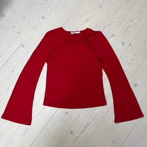Röd tröja NA-KD - Röd tunn långärmad med knut från NA-KD. Använd en gång. Nypris 349kr.