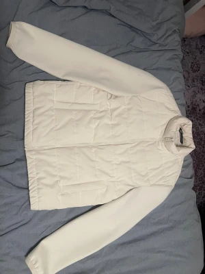 Vit quiltad pufferjacka från Zara - Snygg vit cardigan från Zara i storlek S. Jackan har quiltad framsida, två fickor och dragkedja hela vägen upp till kragen. 