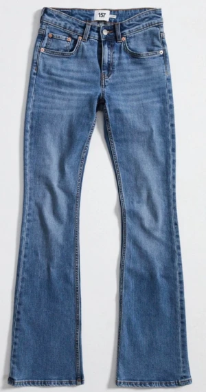 Lager 157 blå bootcut jeans - Snygga blå lager 157 jeans med klassisk bootcut passform och fem fickor. Jeansen har en medelhög midja och är tillverkade i slitstarkt denim med lätt tvättad look. Perfekta för dig som gillar retrostil och vill ha ett par jeans med lite extra vidd vid benslutet.