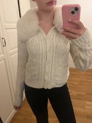 Snygg kofta med påtagbar fuskpäls - Snygg och unik kofta med en fuskpäls som går att knäppa av och på. Jättefin både med och utan. Passar till alla outfits! Storlek M men kan tänka mig att den även sitter snyggt på en med S.