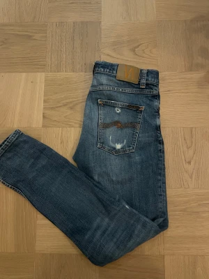 Nudie jeans - Nudie jeans, modellen heter grim Tim och sitter väldigt fint och rakt. Varan är i fint skick och jeansen har najs slitningar och fin tvätt. Storleken är 31/32. Hör av er för mer detaljerade frågor eller bilder med de på!