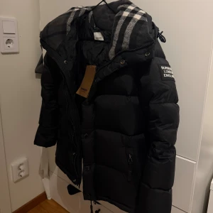 Burberry jacka - Burberry dunjacka/väst i bra skick. En smart detalj är att man kan ta av ärmarna och använda den som väst. Perfekt för både höstkyliga dagar och som varmt lager under vintern. Den är i bra skick, jag har använt den flera gånger men den är fortfarande i mycket bra skick - vid funderingar är det bara att skriva.