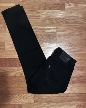 Svarta Levi's 512 jeans slim fit - Svarta Levi's 512 jeans med slim passform och klassisk femficksdesign. Jeansen har en snygg svart läderpatch bak och Levi's röda etikett på bakfickan. Perfekt för dig som gillar stilrena och tajta jeans.