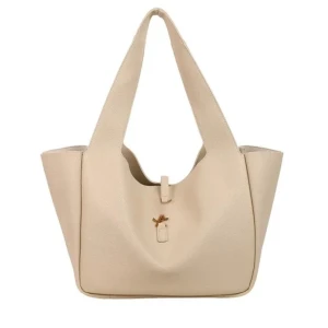 Beige axelväska i skinn - Stilren beige axelväska i skinn med breda axelband och enkel knyt-detalj framtill. Väskan har en rymlig design och passar perfekt för dig som vill ha plats för allt du behöver under dagen. Snygg och enkel att matcha till olika outfits.