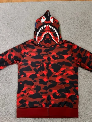 Röd bapestar hoodie - Jag säljer en röd bapestar hoodie i storlek S den är i bra skick och har använts ett fåtal gånger 