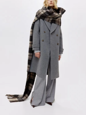 Grå dubbelknäppt ullkappa från H&M - Snygg grå kappa i ullmix med dubbelknäppning och breda slag. Kappan har två framfickor, knappar i mörkbrunt och uppvikta ärmslut. Rak och lite oversized passform som ger en cool och avslappnad look.