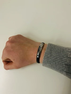 Armband svart/silver - Snyggt armband gjort av gummi och silver. Riktigt fett och passar in till alla stilar.