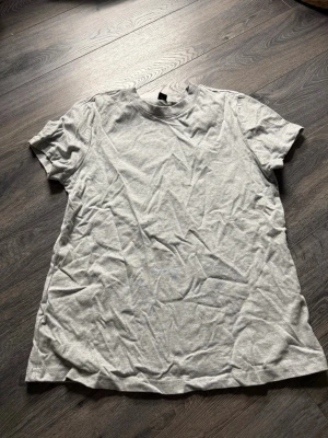 Ljusgrå basic t-shirt från shein - Enkel ljusgrå t-shirt med rund hals och korta ärmar. Perfekt till jeans eller shorts för en clean och avslappnad stil.
