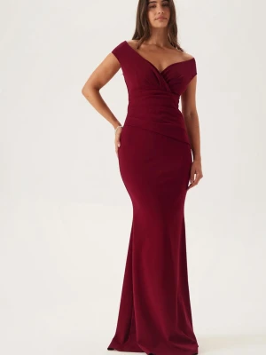 Vinröd balklänning  - Supersnygg vinröd långklänning med figurnära passform och v-ringad omlott upptill. Klänningen har offshoulder-ärmar och markerad midja som framhäver siluetten. Perfekt för bal eller festligare tillfällen. Aldrig använd med prislapp kvar