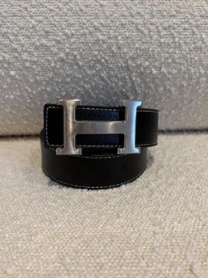 H-bälte - Ett svart H-bälte perfekt för dig som gillar mode och stil, bältet har ett H med färgen silver och är ett fint märke och ett välkänt märke från Frankrike Paris. Kom dm för eventuella frågor 🧐pris kan diskuteras 💯. 