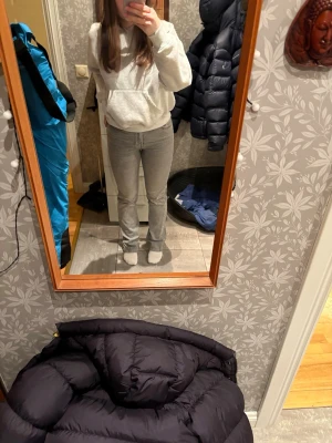 Gråa raka jeans  - Säljer ett par ljusgrå jeans med klassisk rak passform. Jeansen har fem fickor, bälteshällor och stängs med knapp och dragkedja. Materialet är jeans i bomull. 