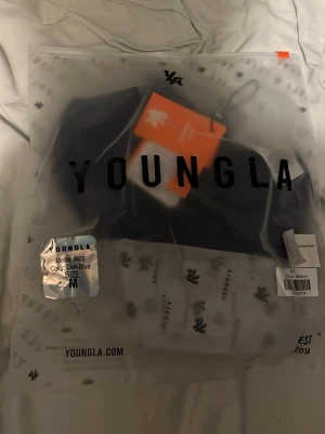 Blå compression shirt youngla  - Bilden visar en förpackning från YoungLA med texten 'Model #465' och färgen 'Dark Blue', storlek M.  Compression tröjan sitter bra på gymmet och du kommer få många komplimanger 
