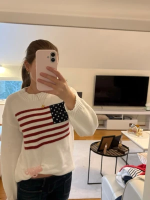 Vit stickad tröja med flaggtryck - Säljer den här jättefina tröjan med tryck i storlek S. Tröjan är i nytt skick och säljer den för 100kr. Pris kan diskuteras🩷