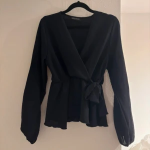 Svart omlottblus från Missay -  svart omlottblus från Missay med långa ärmar och knyt i midjan. Toppen har inga effekter på nåt sätt! Pris kan diskuteras vid snabba köp❤️passar xs-s