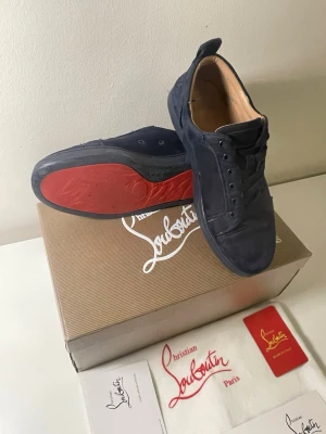 Christian Louboutin  - Säljer ett par mörkblå Christian Louboutin i mjuk mocka med klassisk röd sula. Skorna har används ett par gånger och är lite slitna på baksidan annars är det bra!. Kommer med originalkartong och dustbag. 