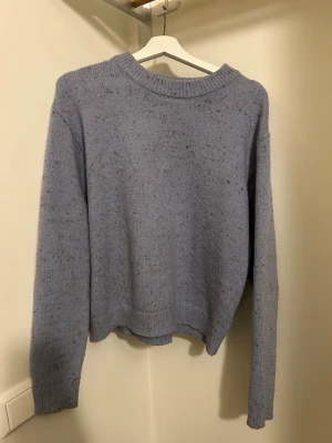 Ljusblå stickad tröja Carin Wester - Mysig ljusblå stickad tröja från Carin Wester i storlek S. Tröjan har färgglada små prickar i garnet som ger en unik look. Rund halsringning, ribbade muddar och lång ärm. 
