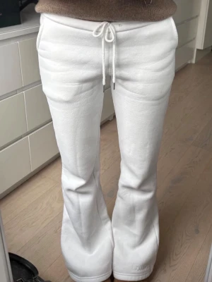 Vita bootcut mjukisbyxor med snörning - Säljer ett par vita mjukisbyxor från Nitted med bootcut passform och snörning i midjan. Byxorna har låg midja, raka ben som blir vidare nedtill och är gjorda i mjukt material. Perfekta för en chill och avslappnad stil. Säljer då det inte passa mig. Endast använda en gång helt nya. Jag är 166cm lång och dom är bra i längden. Köpta för 499kr