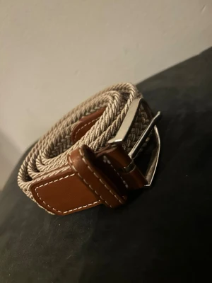 Flätat skärp beige - Säljer ett begie färgat skärp billigt från onewear!