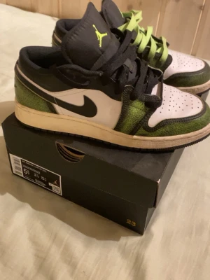 Air Jordan 1 Low SE "Wear Away - Electric Green" (Strl 38) - Säljer nu mina Jordan 1 Low SE "Wear-Away Electric Green" då de inte kommer till användning. Skorna är endast använda ca 5–10 gånger och är i fint skick! Detta är en specialmodell där det svarta lädret är gjort för att slitas ner med tiden och avslöja mer av den gröna färgen under, vilket ger dem en unik look. • Storlek: 38 (5.5Y) • Skick: 7.5/10 (sparsamt använda) • Tillbehör: Originalkartong (OG box) medföljer självklart! 