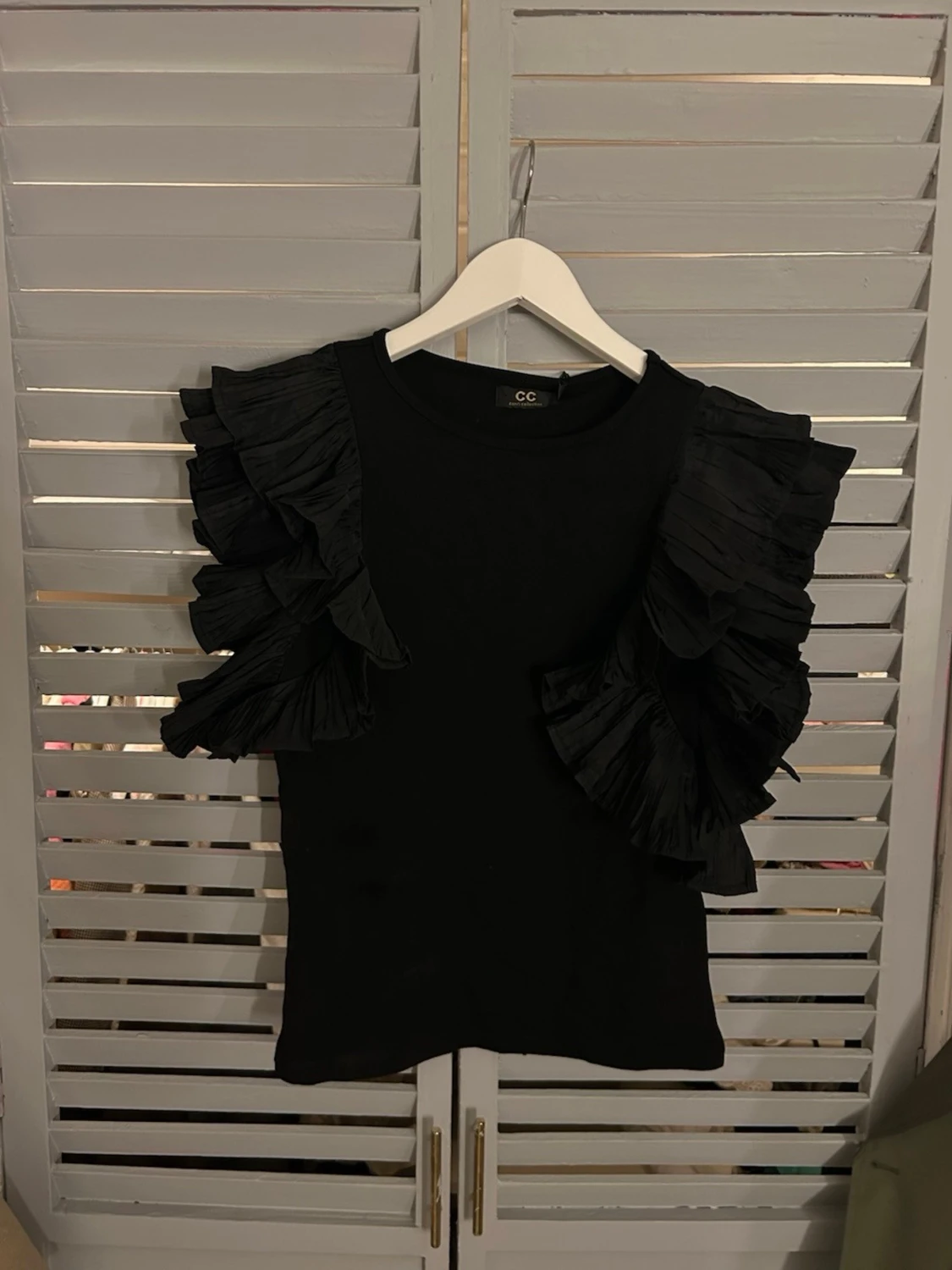 Svart topp med volangärmar Capri Collection