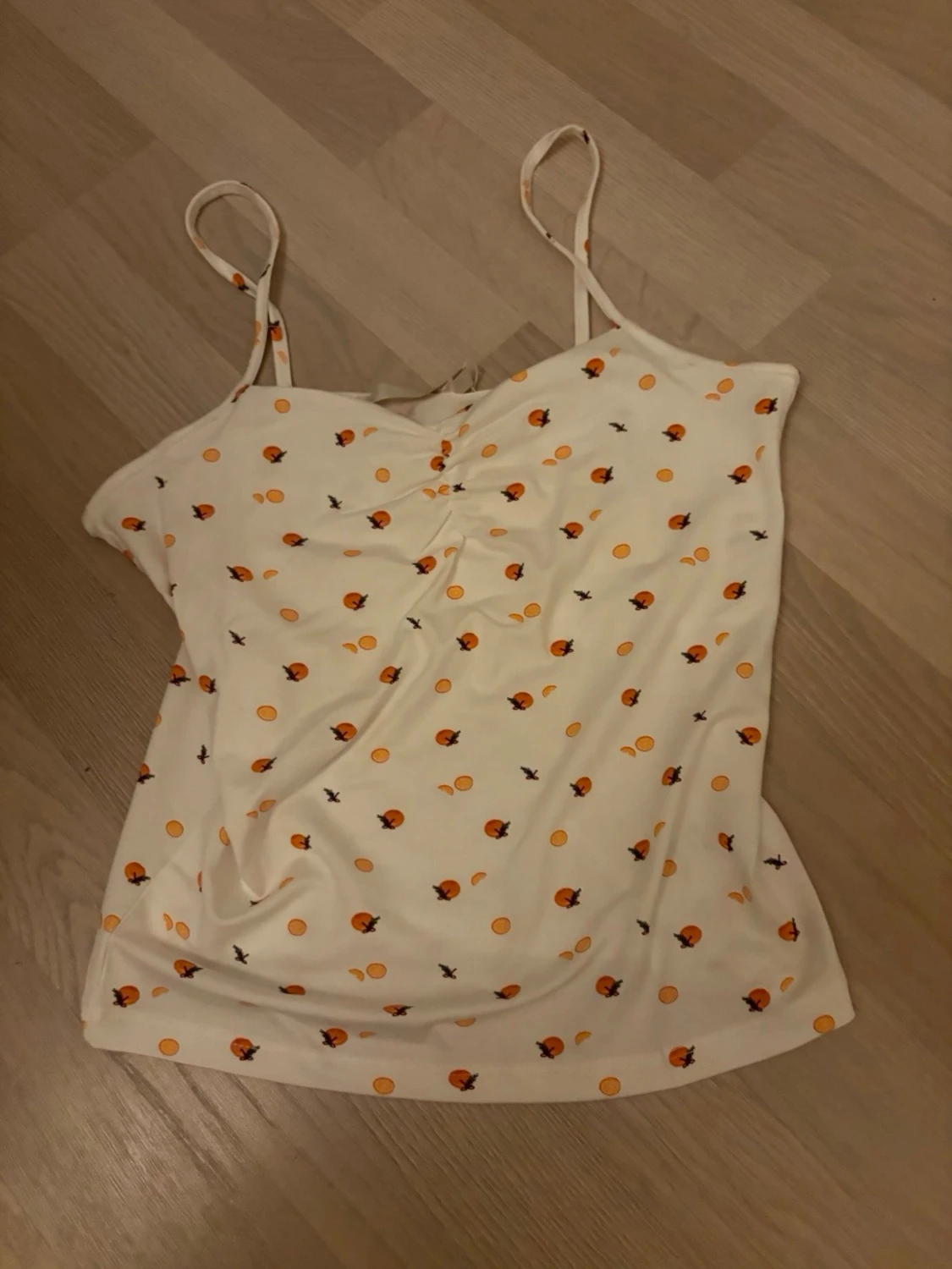 Vit linnetopp med apelsinmönster